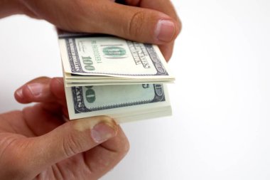 Beyaz arka planda izole edilmiş bir tomar doları tutan afro bir el.