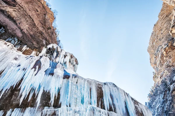 Cachoeira congelada nas montanhas ao pôr do sol . — Fotografia de Stock