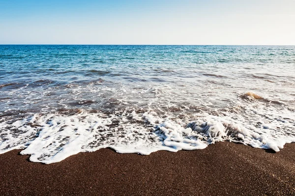 Schöner Strand mit türkisfarbenem Wasser und schwarzem Sand — Stockfoto