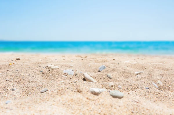 Verschwommener Hintergrund mit weißem Sand und blauem Meer — Stockfoto