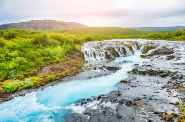 Gün batımında mavi su ile Bruarfoss şelale. 