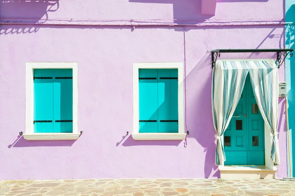 Дом с фиолетовыми стенами и бирюзовыми окнами . — стоковое фото