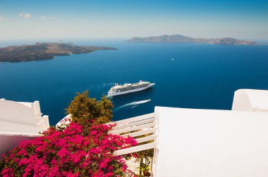 Santorini Adası, Yunanistan 'da beyaz mimari. Terasta deniz manzaralı çiçekler. Seyahat hedefleri kavramı