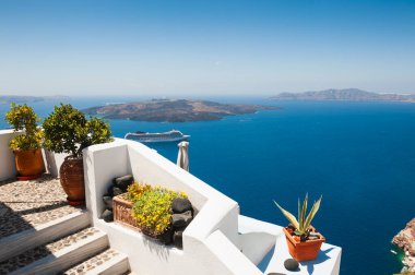 Santorini Adası, Yunanistan 'da beyaz mimari. Terasta deniz manzaralı çiçekler. Seyahat hedefleri kavramı