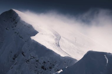 Kış kayak merkezinde dağın tepesinde kayak yamacı. Rosa Khutor, Sochi, Rusya. Güzel karla kaplı dağlar ve orman, kış manzarası