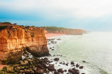 Portekiz, Algarve 'deki Atlantik Okyanusu kıyısındaki kayalar. Güzel yaz deniz manzarası, ünlü seyahat beldesi.