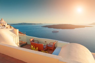 Yunanistan 'ın Santorini adasında güzel bir gün batımı. Terasta deniz manzaralı sandalyeler. Seyahat hedefleri kavramı