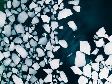 Bahar ayında Baykal Gölü 'nde buz kütleleri arasında yüzen kano. Hava aracı görüntüsü. Baykal Gölü, Sibirya, Rusya