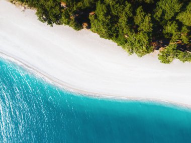 Turkuaz suyu, beyaz çakıl taşları ve yeşil ağaçları olan tropik bir sahil. Hava aracı görüntüsü. Yaz doğası geçmişi. Seyahat hedefi kavramı