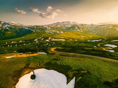 Mountains and volcanoes with snow at sunset on Vilyuchinsky pass in Kamchatka peninsula, Russia. Beautiful summer landscape clipart
