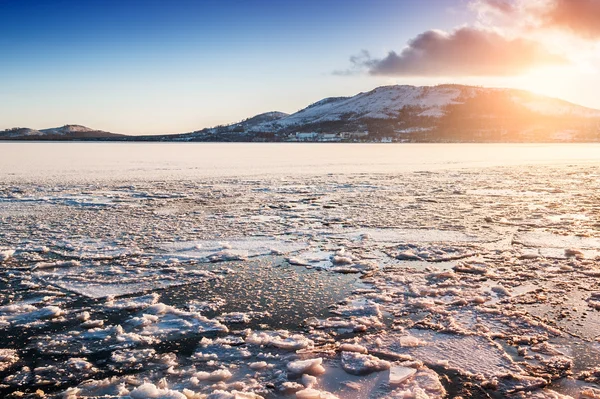 Ice and snow on the lake at sunset — Stock Photo, Image