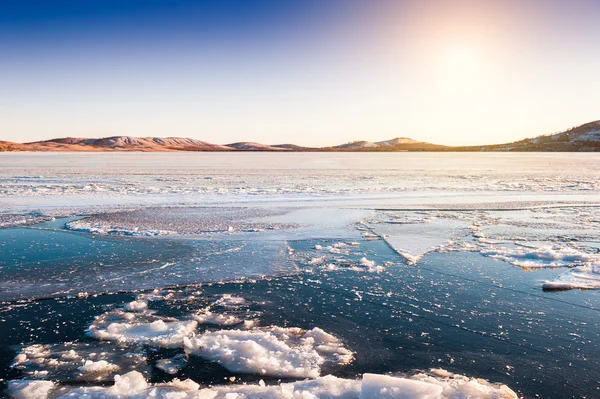 Ice and snow on the lake at sunset — Stock Photo, Image