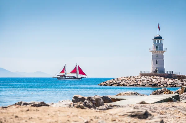 Lighthouse and tourist yacht by the sea — Stock Photo, Image