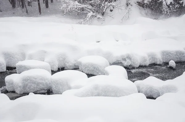 Snowfall on the mountain river — Stock Photo, Image