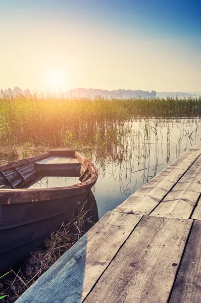 Old boat on the coast of lake at sunset — Stock Photo, Image