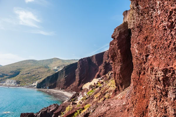Bella spiaggia rossa con acqua turchese e grandi rocce — Foto Stock