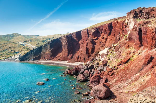 Bella spiaggia rossa con acqua turchese e grandi rocce — Foto Stock