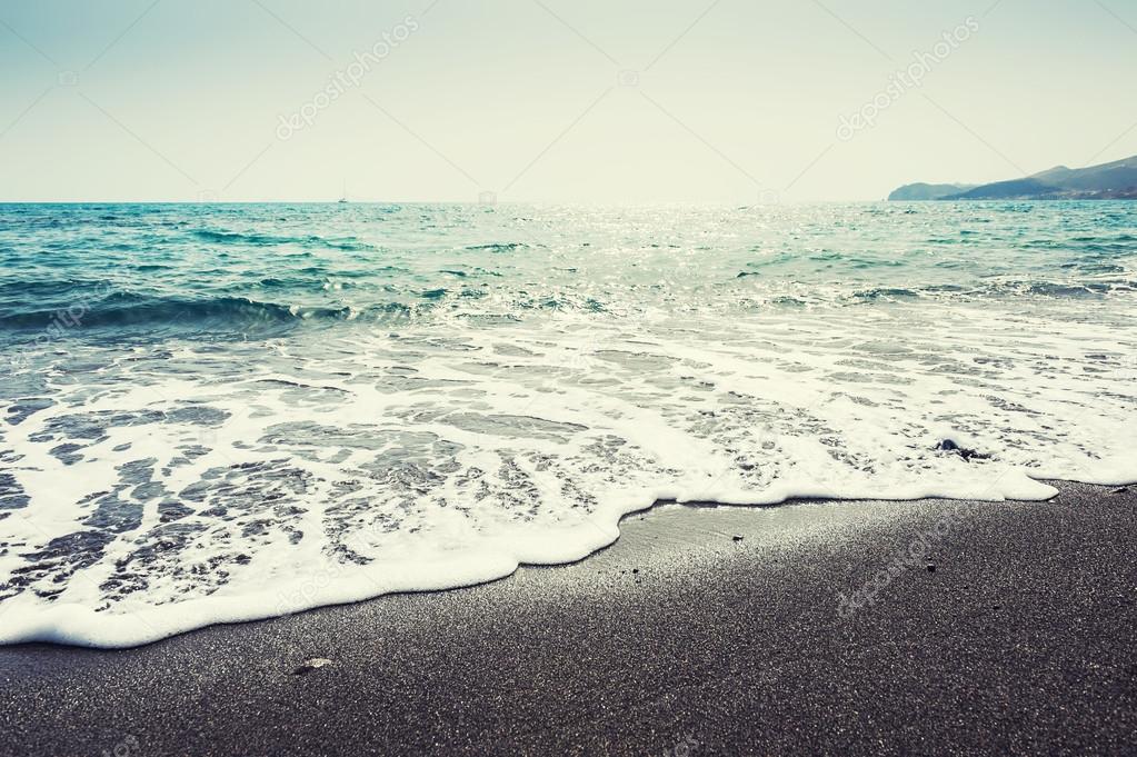 Beautiful beach with turquoise water and black sand.