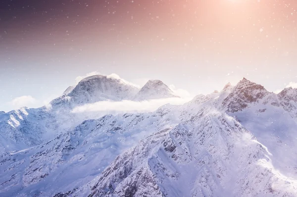 Beau paysage hivernal avec des montagnes enneigées au coucher du soleil — Photo