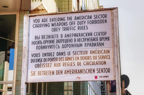 Historisk skilt ved Checkpoint Charlie i Berlin - Stock-foto