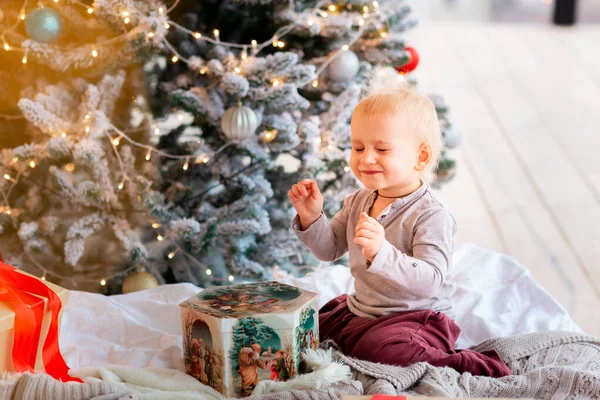 クリスマスツリーの近くにプレゼントボックスを開く幸せな小さな赤ちゃんの男の子 クリスマスの朝のコンセプト — ストック写真