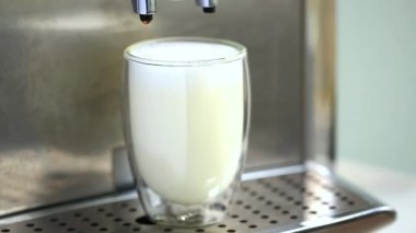 Kahve makinesinden akan kahve ve bardaktan dökülen kahve. Evde sıcak Latte yapıyorum. Taze kahve akıyor. Sabahları kavrulmuş sade kahve içmek..
