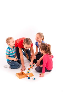 Beyazlar üzerinde izole edilmiş yapı taşlarıyla oynayan mutlu çocuklar. Takım çalışması, yaratıcılık kavramı.