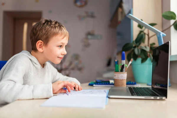 学校の宿題をする家で勉強するかわいい少年 テーブルの上で本やノートを訓練する 遠隔オンライン教育 — ストック写真