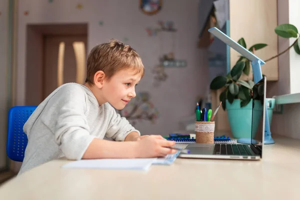 学校の宿題をする家で勉強するかわいい少年 テーブルの上で本やノートを訓練する 遠隔オンライン教育 — ストック写真