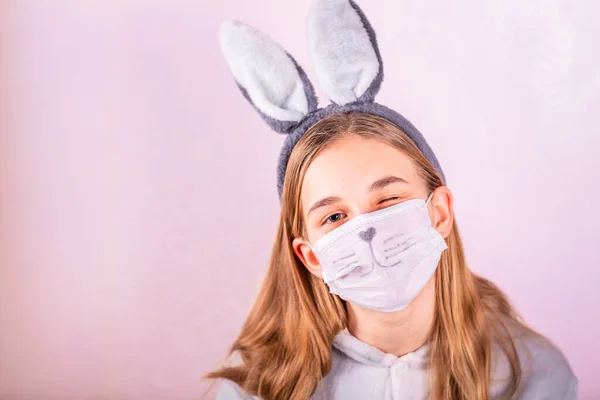 Девочка Кроличьих Ушах Голове Защитной Маске Цветными Яйцами Розовом Фоне — стоковое фото