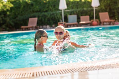 Tatil beldesinde havuzda eğlenen mutlu çocuklar