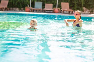 Tatil beldesinde havuzda eğlenen mutlu çocuklar