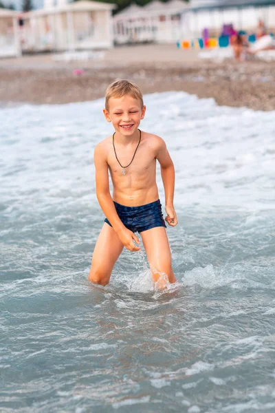 海で波を楽しんでいる幸せなアクティブな小さな男の子 — ストック写真