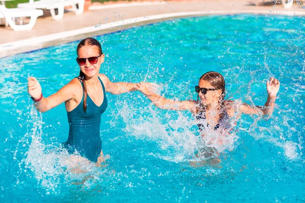 Mutlu güzel kızlar tatil köyündeki havuzda eğleniyor.