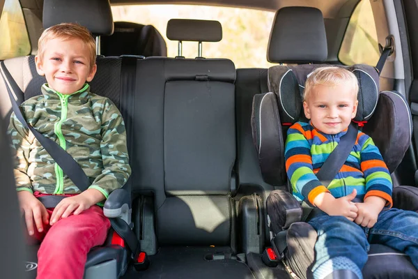 Två Små Pojkar Sitter Bilstol Och Bältesstol Fastspänd Bilen Barnbilssäkerhet — Stockfoto