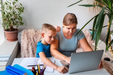 Anne ve çocuk karantina sırasında evden çalışmaya çalışıyorlar. Evde kalıp, koronavirüs salgını sırasında ev konsepti üzerinde çalışmak.