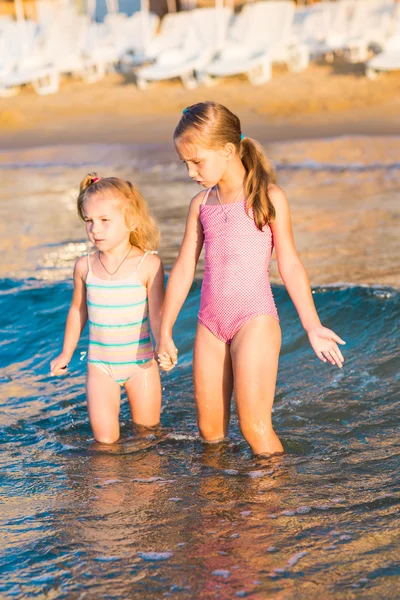 Dos niños adorables jugando en el mar en una playa —  Fotos de Stock