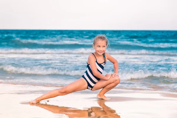 Sahilde güzel küçük kız excercising — Stok fotoğraf