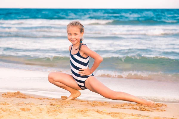 Hermosa niña haciendo ejercicio en la playa — Foto de Stock