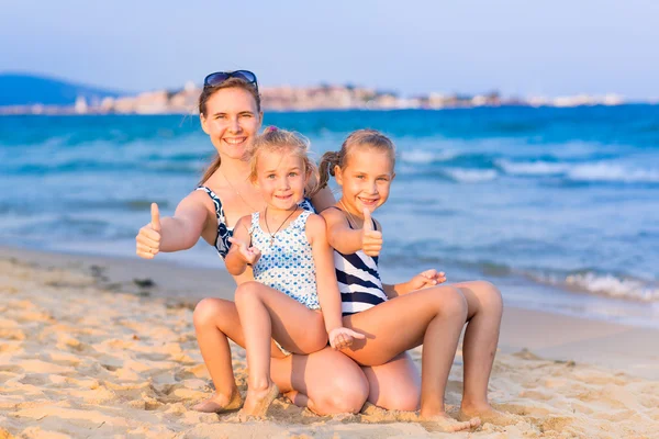 Madre con sus hijas en la orilla del mar — Foto de Stock