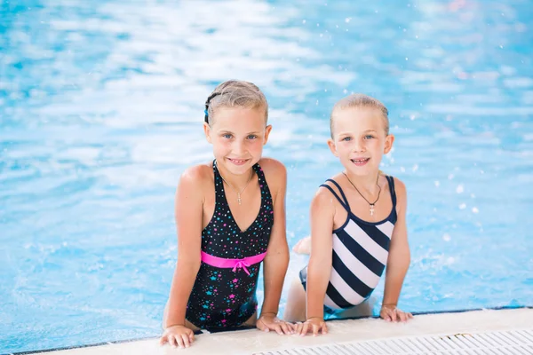 Two cute little girls in swimming pool — Stock Photo, Image