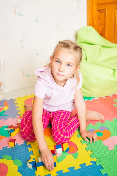 Glückliches kleines Mädchen, das mit Blöcken spielt — Stockfoto