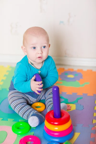 Niedliches kleines Baby spielt mit buntem Spielzeug — Stockfoto