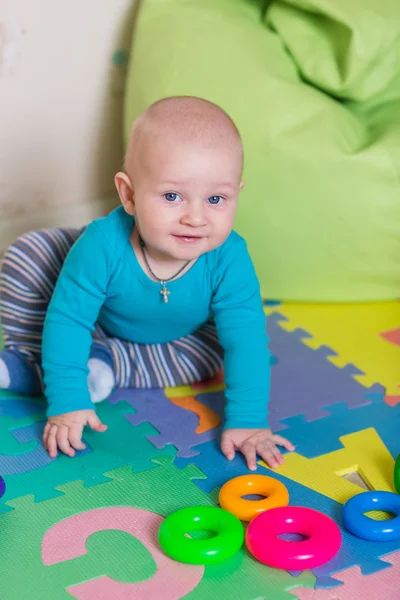 Niedliches kleines Baby spielt mit buntem Spielzeug — Stockfoto