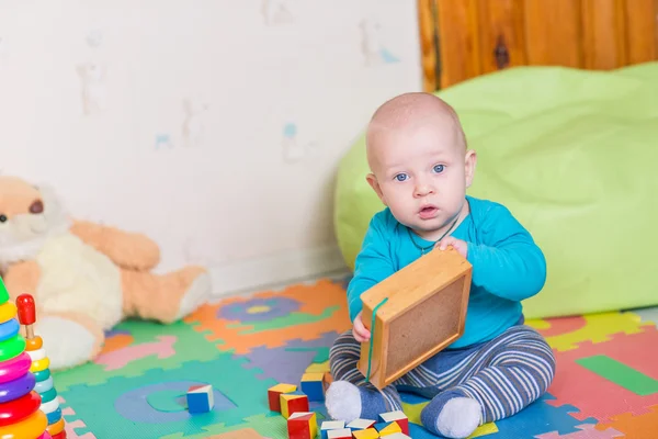 Carino piccolo bambino che gioca con giocattoli colorati — Foto Stock