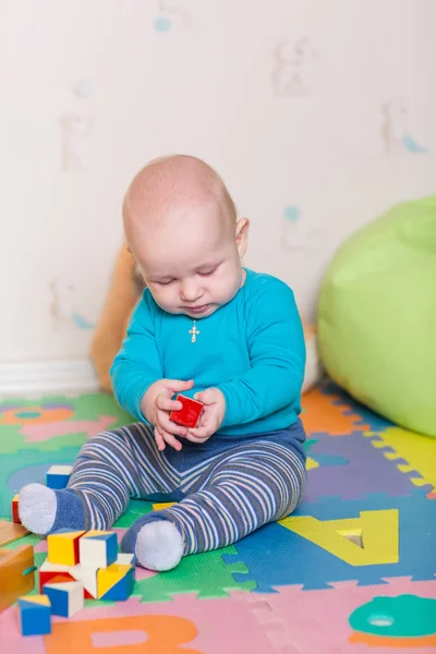 Niedliches kleines Baby spielt mit buntem Spielzeug — Stockfoto