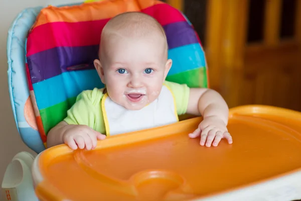 Adorable baby eating in high chair — Stock Photo, Image