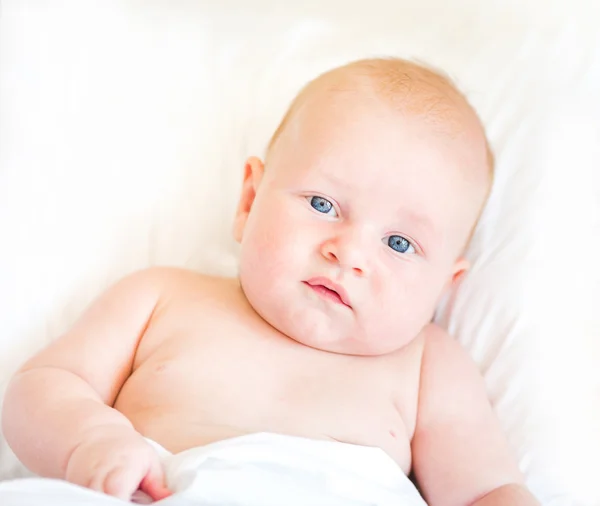 Tranquillo neonato sdraiato su un letto — Foto Stock
