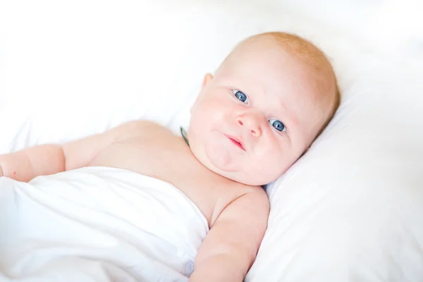 Bebê recém-nascido pacífico deitado em uma cama — Fotografia de Stock