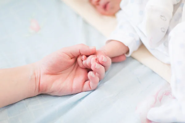 Mother holding the hand of her new born baby — Stock Photo, Image